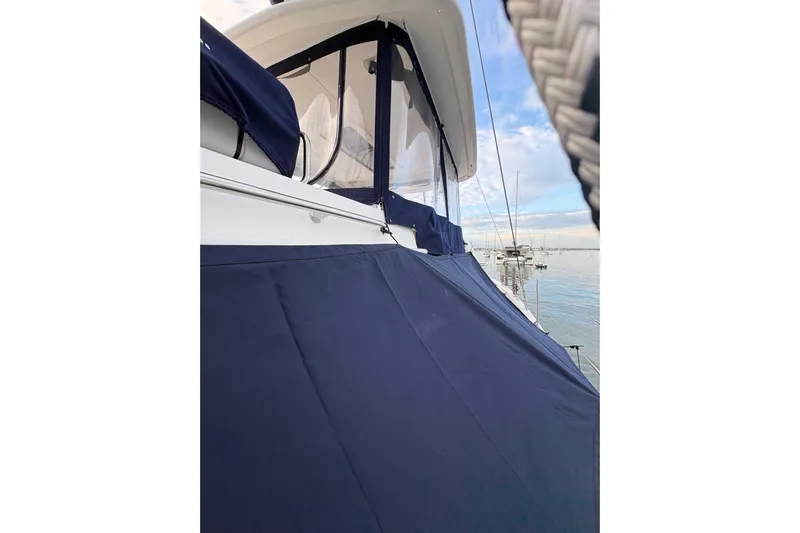 Flip Flops Yacht Photos Pics 2017 Leopard 48 yacht with blue canvas cover, docked in calm waters.