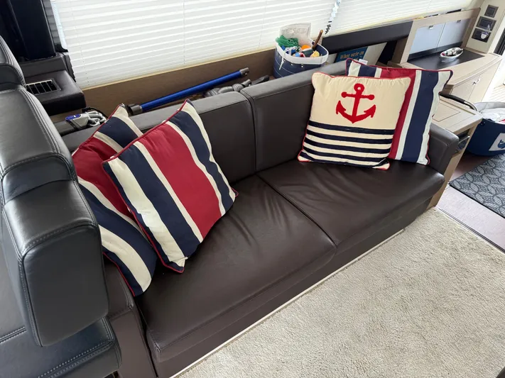 Smiles Away Yacht Photos Pics Luxurious leather sofa with nautical-themed cushions on a 2018 Prestige 500 S yacht.