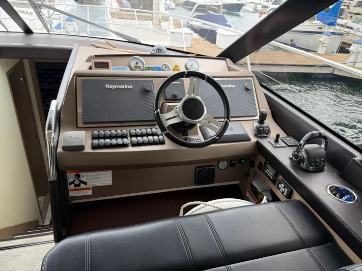 Smiles Away Yacht Photos Pics Cockpit of 2018 Prestige 500 S yacht with Raymarine navigation system and leather seating.