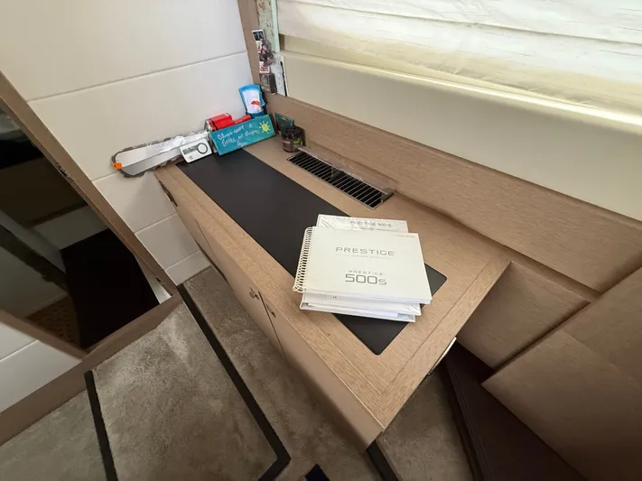 Smiles Away Yacht Photos Pics Manuals for 2018 Prestige 500 S yacht on a wooden desk.