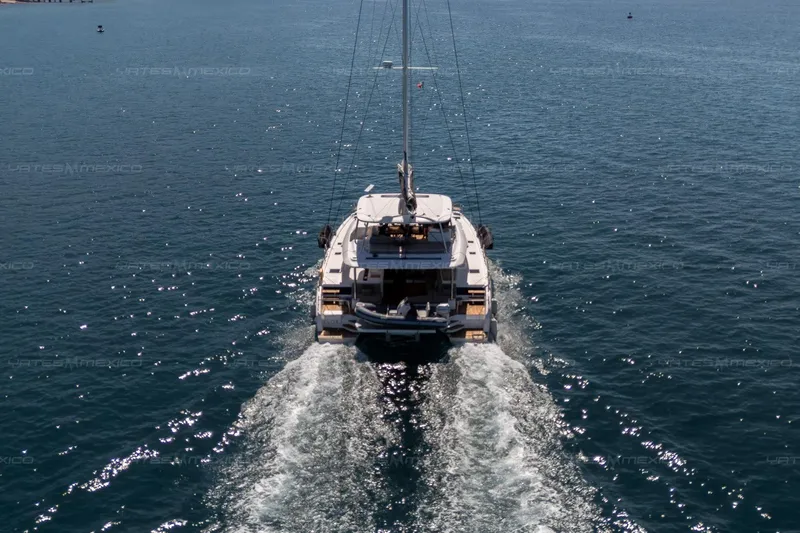  Yacht Photos Pics 2023 Lagoon 55 yacht cruising on open sea, leaving a wake behind.