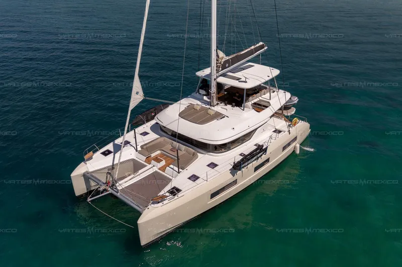  Yacht Photos Pics 2023 Lagoon 55 catamaran sailing on clear blue waters.