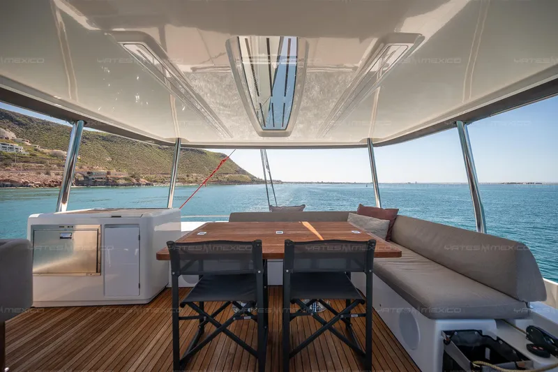  Yacht Photos Pics Luxurious 2023 Lagoon 55 yacht deck with seating, overlooking serene ocean view.