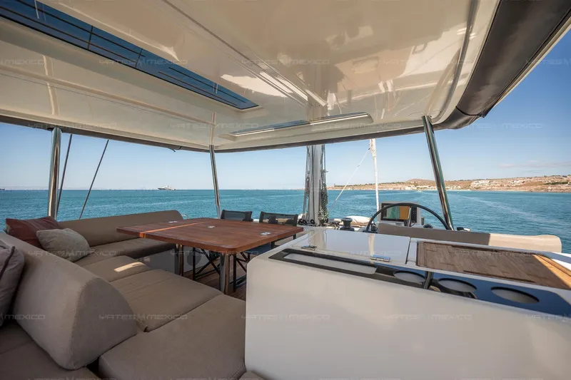  Yacht Photos Pics Luxurious 2023 Lagoon 55 yacht interior with ocean view, featuring comfortable seating and dining area.