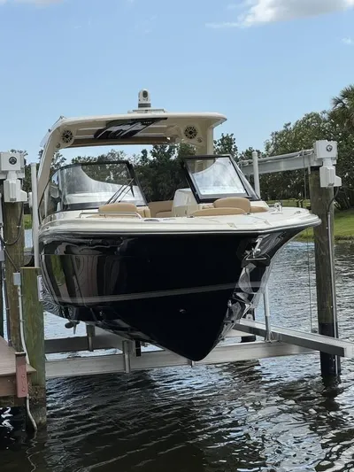  Yacht Photos Pics 2023 Scout 277 Dorado boat on lift, docked by a scenic waterway.