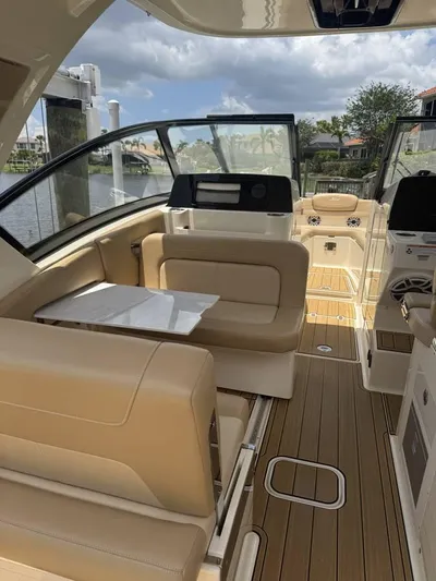  Yacht Photos Pics 2023 Scout 277 Dorado boat interior with beige seating and wooden flooring.