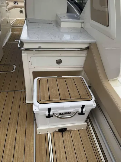  Yacht Photos Pics 2023 Scout 277 Dorado boat interior with teak flooring and cooler storage.