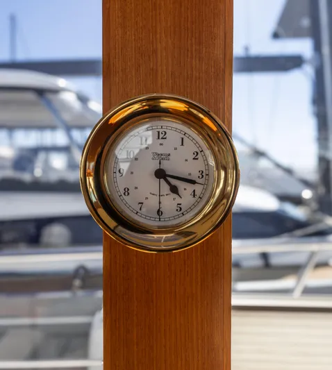 Yeomalt Yacht Photos Pics Brass clock on 2014 Grand Banks 50 Eastbay SX yacht with marina background.