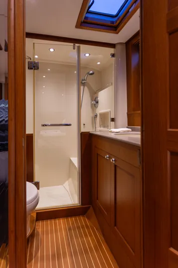 Yeomalt Yacht Photos Pics 2014 Grand Banks 50 Eastbay SX yacht bathroom with wooden cabinetry and glass shower enclosure.