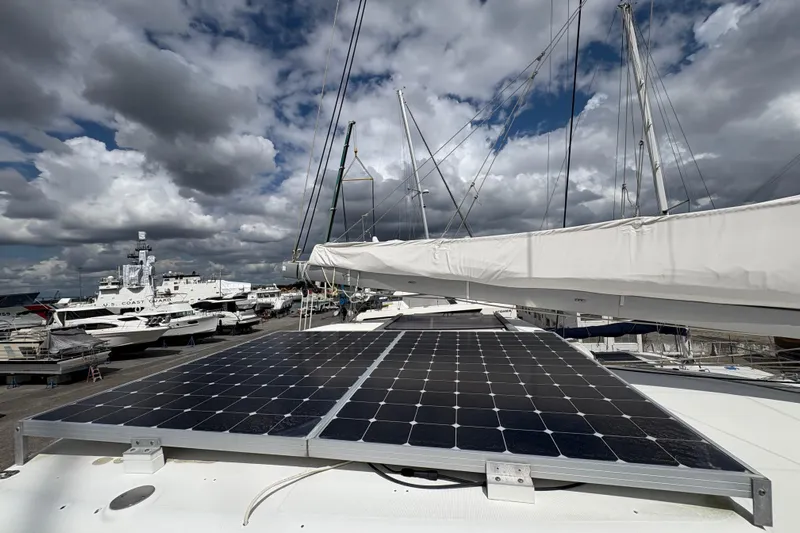 Toucan Deux Yacht Photos Pics 2004 Lagoon 380 catamaran with solar panels docked under cloudy skies.