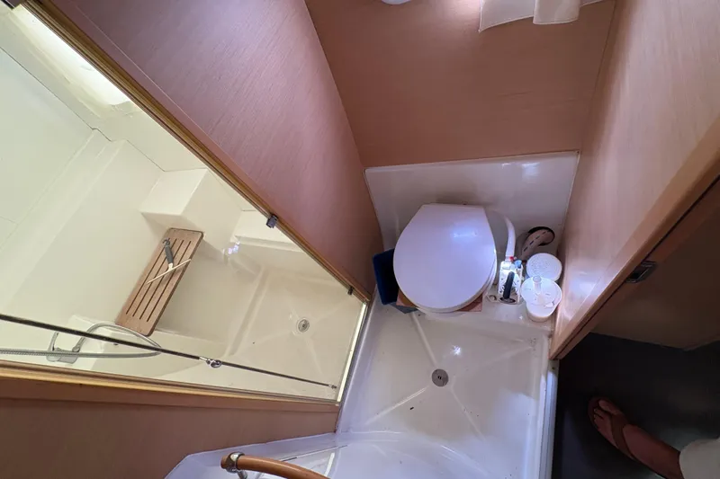 Toucan Deux Yacht Photos Pics Compact bathroom in a 2004 Lagoon 380 catamaran, featuring a shower and toilet.