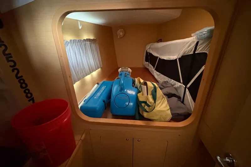Toucan Deux Yacht Photos Pics Interior cabin of 2004 Lagoon 380 catamaran with luggage and equipment.