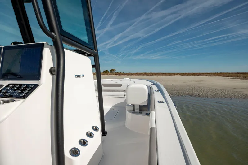  Yacht Photos Pics 2024 Caymas 281 HB boat near sandy shore under clear blue sky.