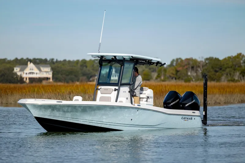  Yacht Photos Pics 2024 Caymas 281 HB boat cruising on a calm lake with scenic background.