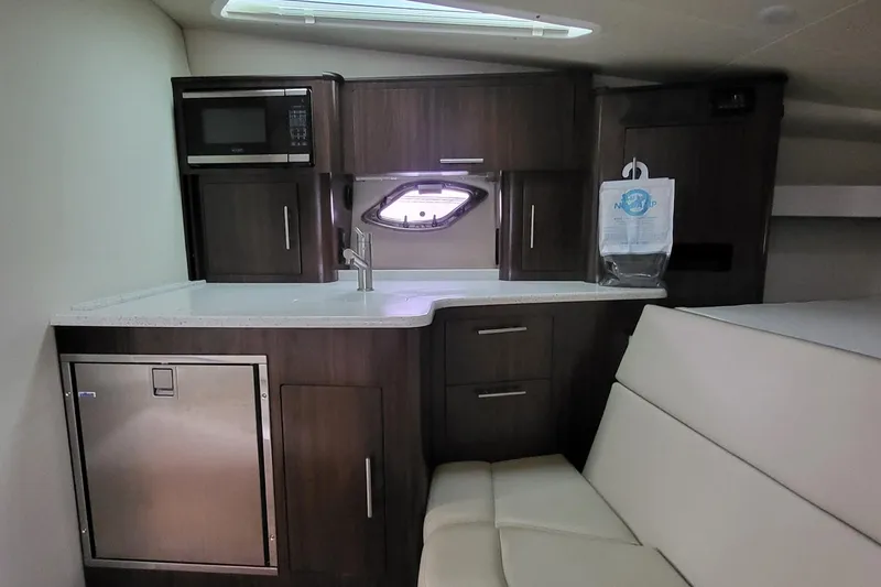  Yacht Photos Pics 2018 Regal 35 Sport Coupe interior kitchen with microwave, sink, and seating area.