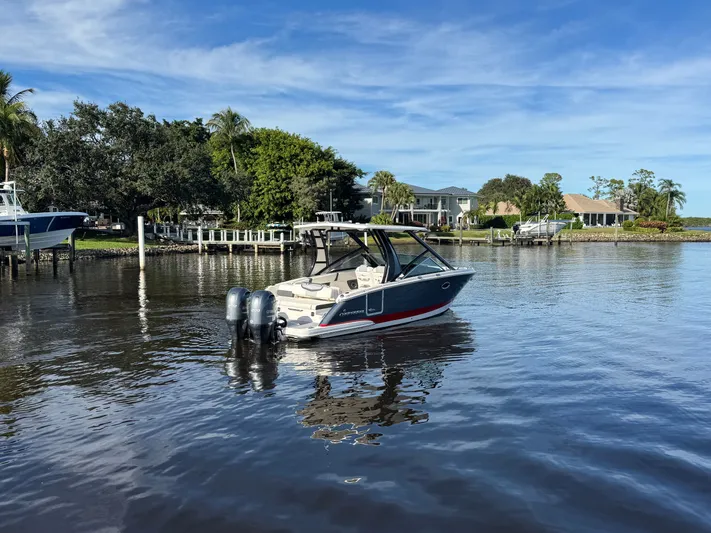  Yacht Photos Pics 2023 Chaparral 280 OSX boat on calm water near dock.