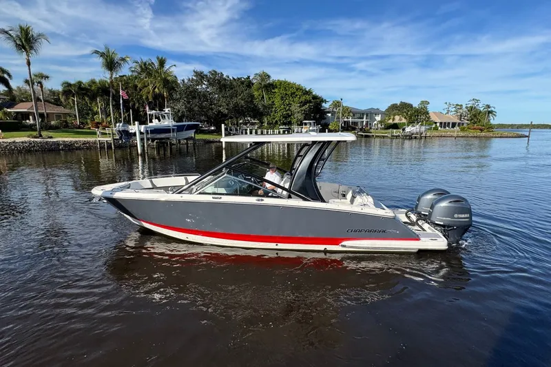  Yacht Photos Pics 2023 Chaparral 280 OSX boat on calm water with palm trees in the background.