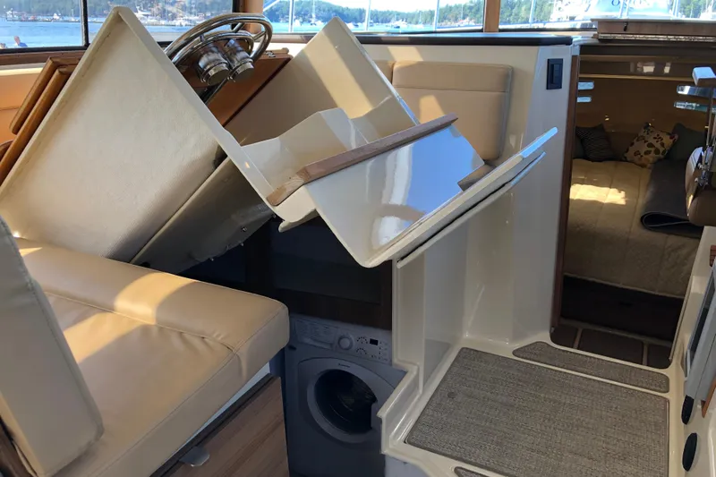  Yacht Photos Pics 2024 Ranger Tugs R-43 CB interior with helm, washer, and cozy cabin view.