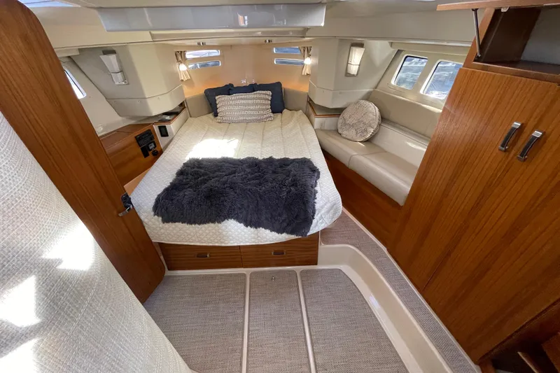  Yacht Photos Pics 2024 Ranger Tugs R-43 CB cabin interior with cozy bed and wooden finishes.