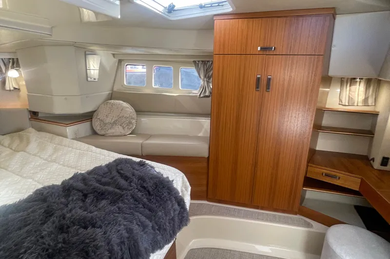  Yacht Photos Pics 2024 Ranger Tugs R-43 CB interior cabin with bed, seating, and wooden cabinetry.