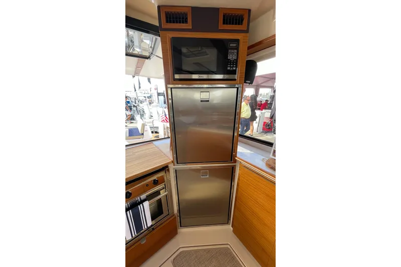  Yacht Photos Pics 2024 Ranger Tugs R-43 CB galley with stainless steel appliances and wood accents.