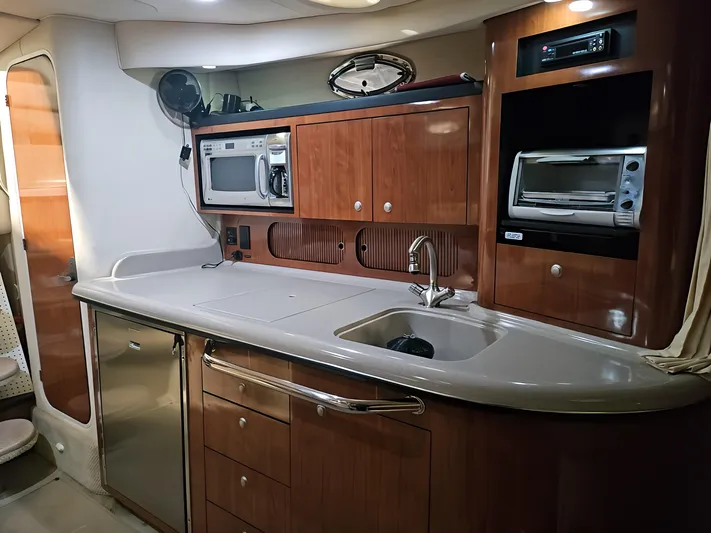  Yacht Photos Pics 2006 Sea Ray 340 Sundancer interior kitchen with wooden cabinets, sink, microwave, and appliances.