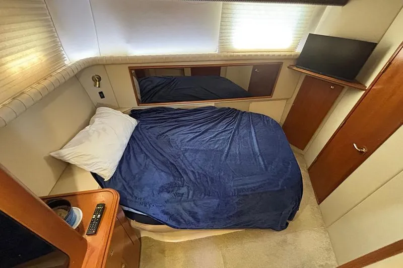  Yacht Photos Pics 2003 Cruisers Yachts 3750 Motoryacht cabin with bed, TV, and wooden cabinetry.