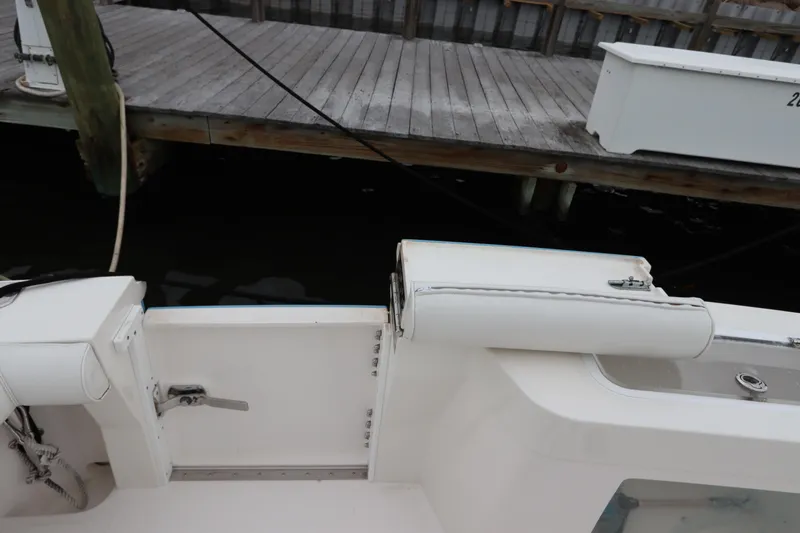  Yacht Photos Pics 2007 Cabo 40 Hardtop Express boat interior near dock, featuring white seating and storage compartments.