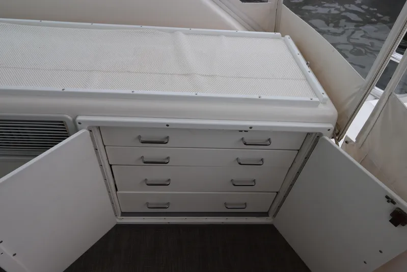  Yacht Photos Pics 2007 Cabo 40 Hardtop Express interior storage with open cabinet and drawers.