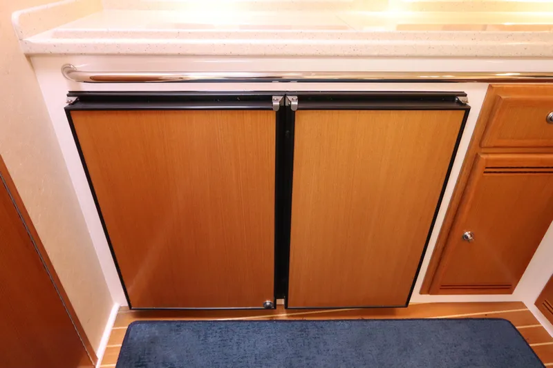  Yacht Photos Pics 2007 Cabo 40 Hardtop Express interior with wooden cabinetry and blue rug.