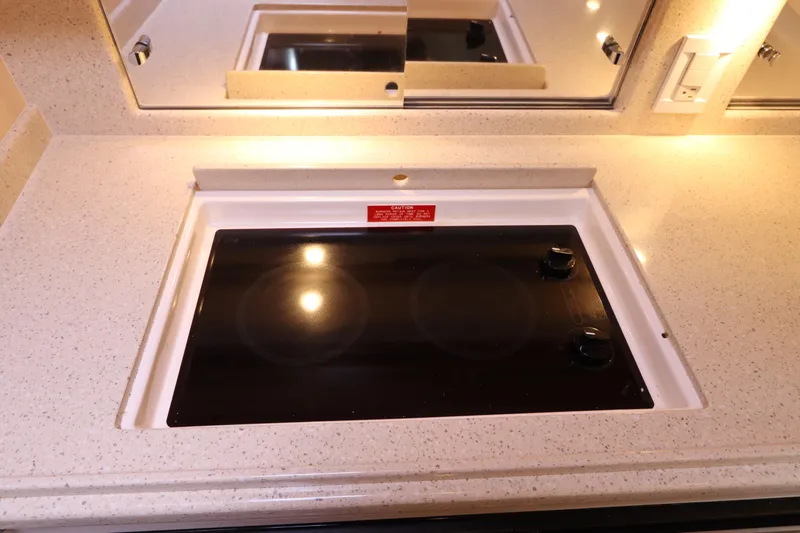  Yacht Photos Pics 2007 Cabo 40 Hardtop Express kitchen with sleek electric cooktop and mirrored backsplash.