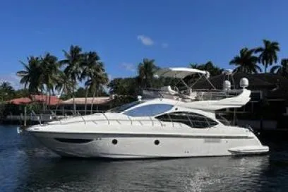  Yacht Photos Pics 2014 Azimut Fly yacht on a serene waterway, surrounded by palm trees and clear blue sky.