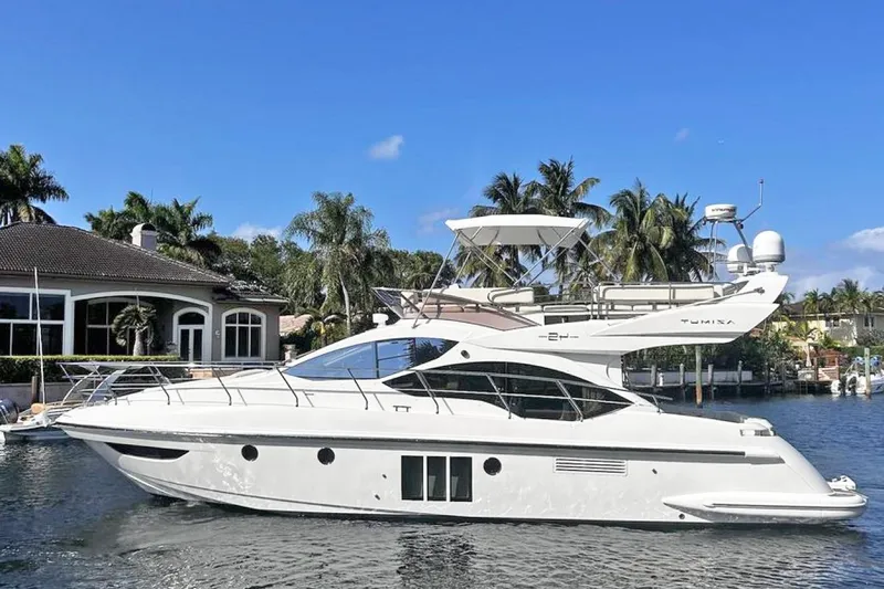  Yacht Photos Pics Luxury 2014 Azimut Fly yacht docked by waterfront home, surrounded by palm trees.