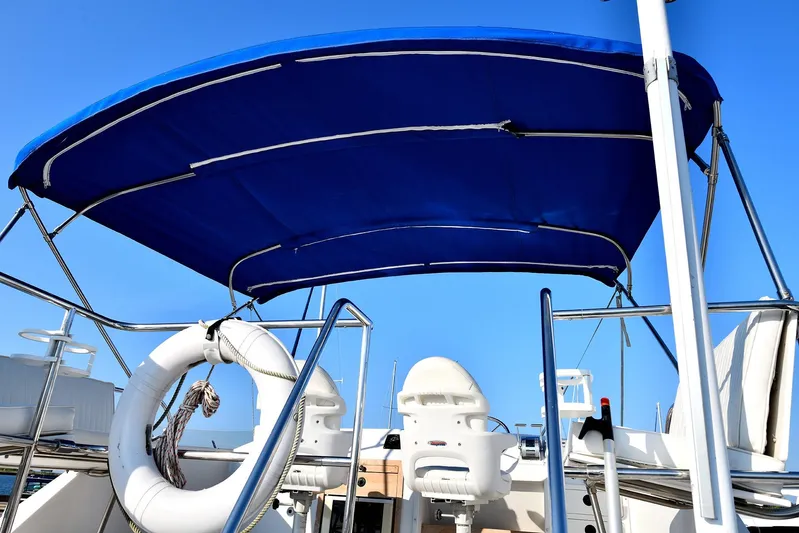 Two Buoys Yacht Photos Pics 2002 PDQ 32 Power Catamaran with blue canopy and life preserver, viewed from the deck.