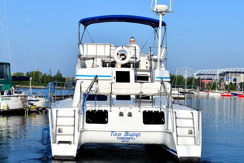 Two Buoys Yacht Photos Pics 2002 PDQ 32 Power Catamaran docked in a marina with blue canopy.