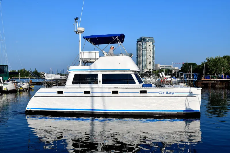 Two Buoys Yacht Photos Pics 2002 PDQ 32 Power Catamaran docked in a marina with cityscape background.