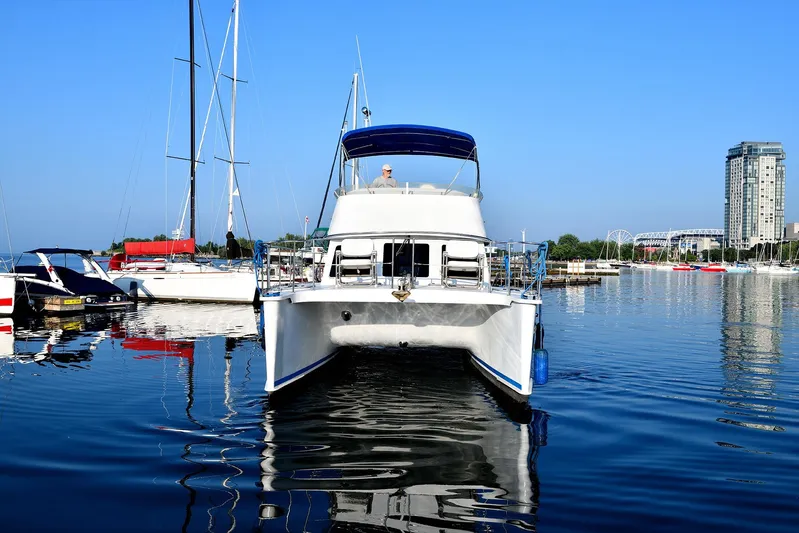 Two Buoys Yacht Photos Pics 2002 PDQ 32 Power Catamaran docked in a marina with clear blue sky.