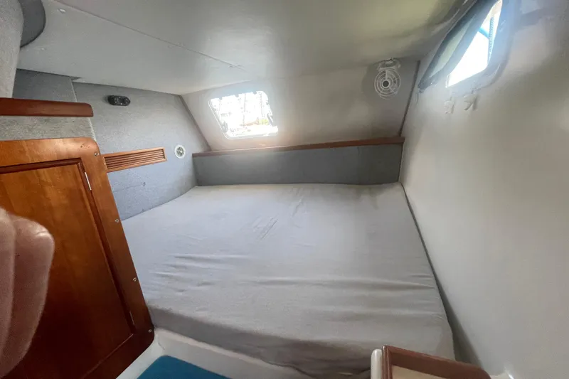 Two Buoys Yacht Photos Pics Interior cabin of 2002 PDQ 32 Power Catamaran with bed and wooden accents.