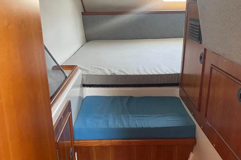 Two Buoys Yacht Photos Pics 2002 PDQ 32 Power Catamaran cabin interior with bed and seating area.