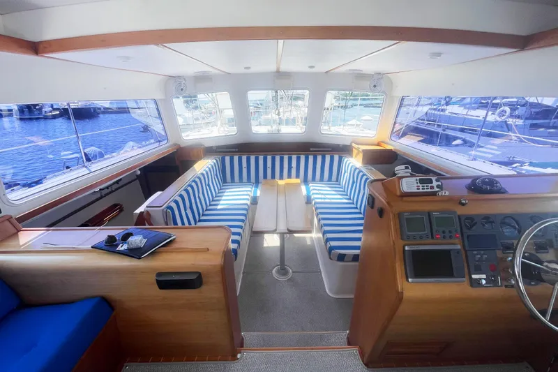 Two Buoys Yacht Photos Pics Interior of 2002 PDQ 32 Power Catamaran with striped seating and navigation controls.