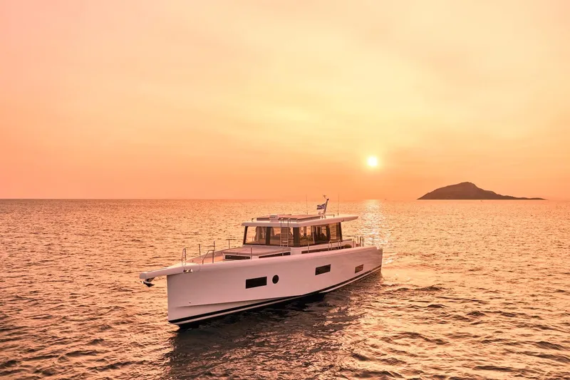  Yacht Photos Pics 2026 Omikron Yachts OT-60 sailing at sunset with island backdrop.