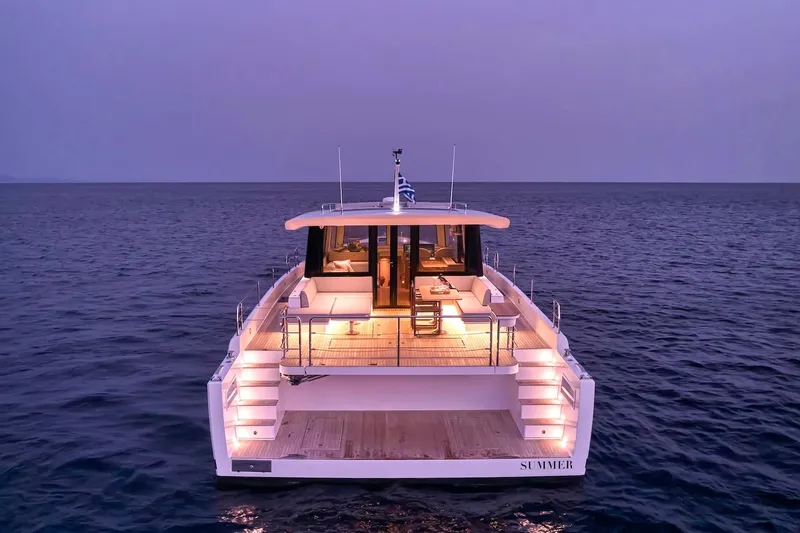  Yacht Photos Pics Luxurious 2026 Omikron Yachts OT-60 illuminated at dusk on open sea.