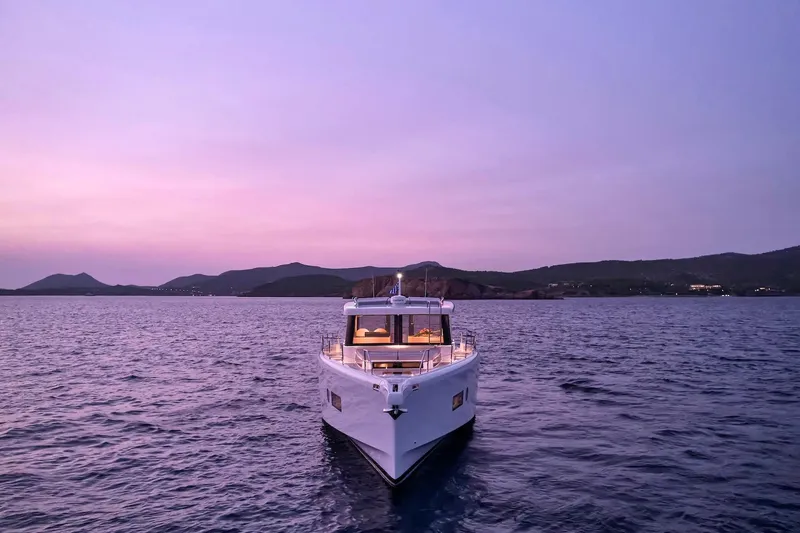  Yacht Photos Pics 2026 Omikron Yachts OT-60 at sunset on tranquil waters.