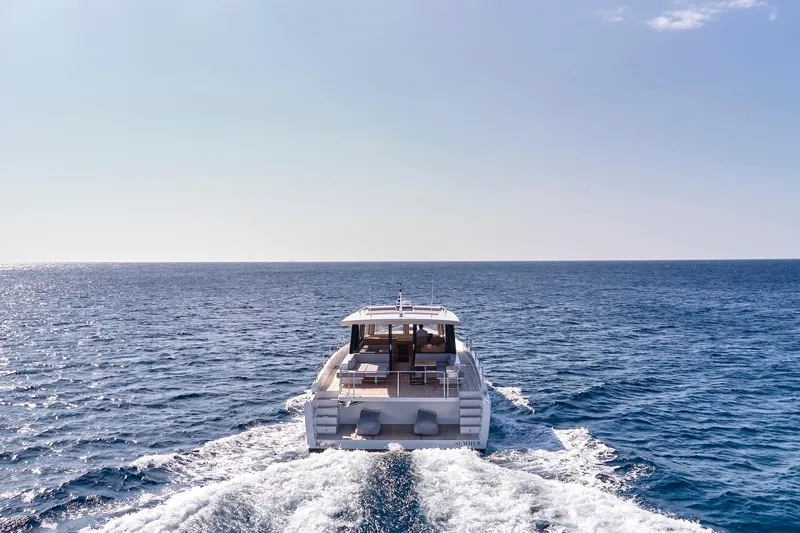  Yacht Photos Pics 2026 Omikron Yachts OT-60 cruising on open sea, rear view.