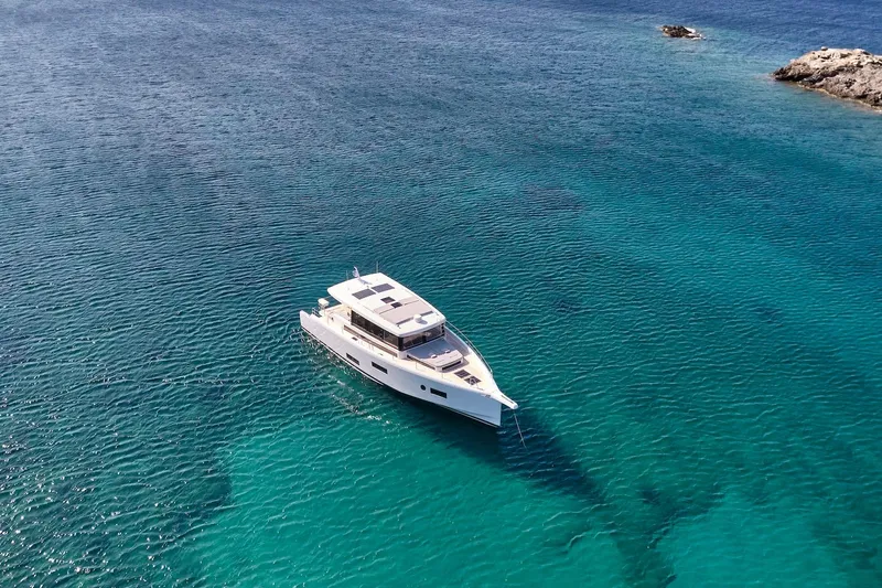  Yacht Photos Pics 2026 Omikron Yachts OT-60 cruising on clear turquoise waters.