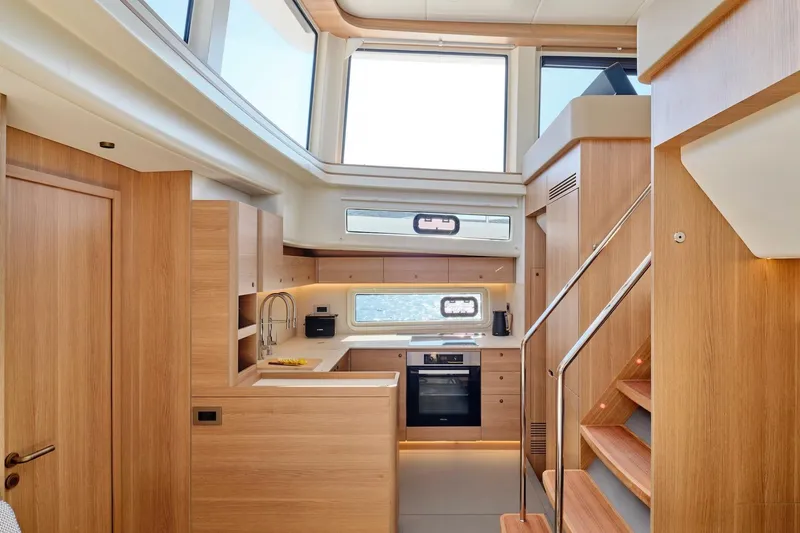 Yacht Photos Pics Modern kitchen interior of 2026 Omikron Yachts OT-60, featuring sleek wood finishes and ample natural light.