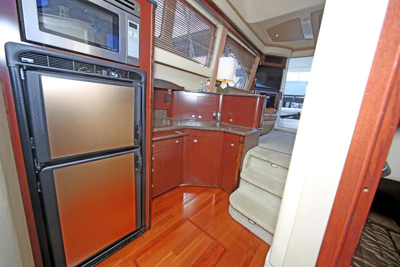 Devine Intervention Yacht Photos Pics Interior of 2007 Sea Ray 44 Sedan Bridge yacht with modern kitchen and wood flooring.