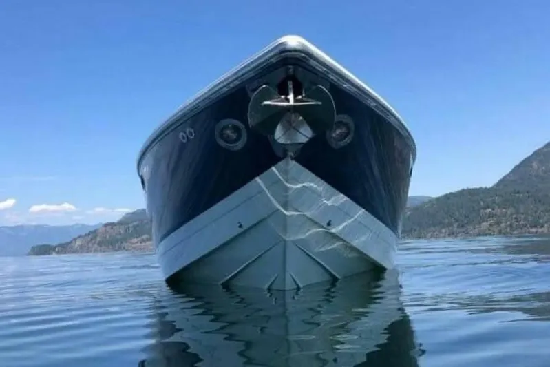  Yacht Photos Pics Front view of a 2005 Cobalt 343 boat on a calm lake with mountains.