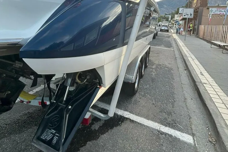  Yacht Photos Pics 2005 Cobalt 343 boat on trailer, parked on street, with visible outdrive and nearby pedestrians.