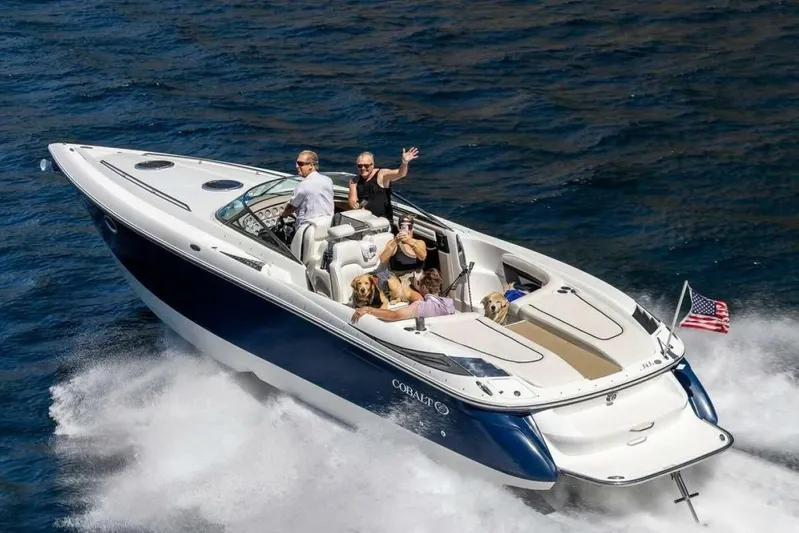  Yacht Photos Pics 2005 Cobalt 343 speedboat cruising with passengers and dogs on open water.